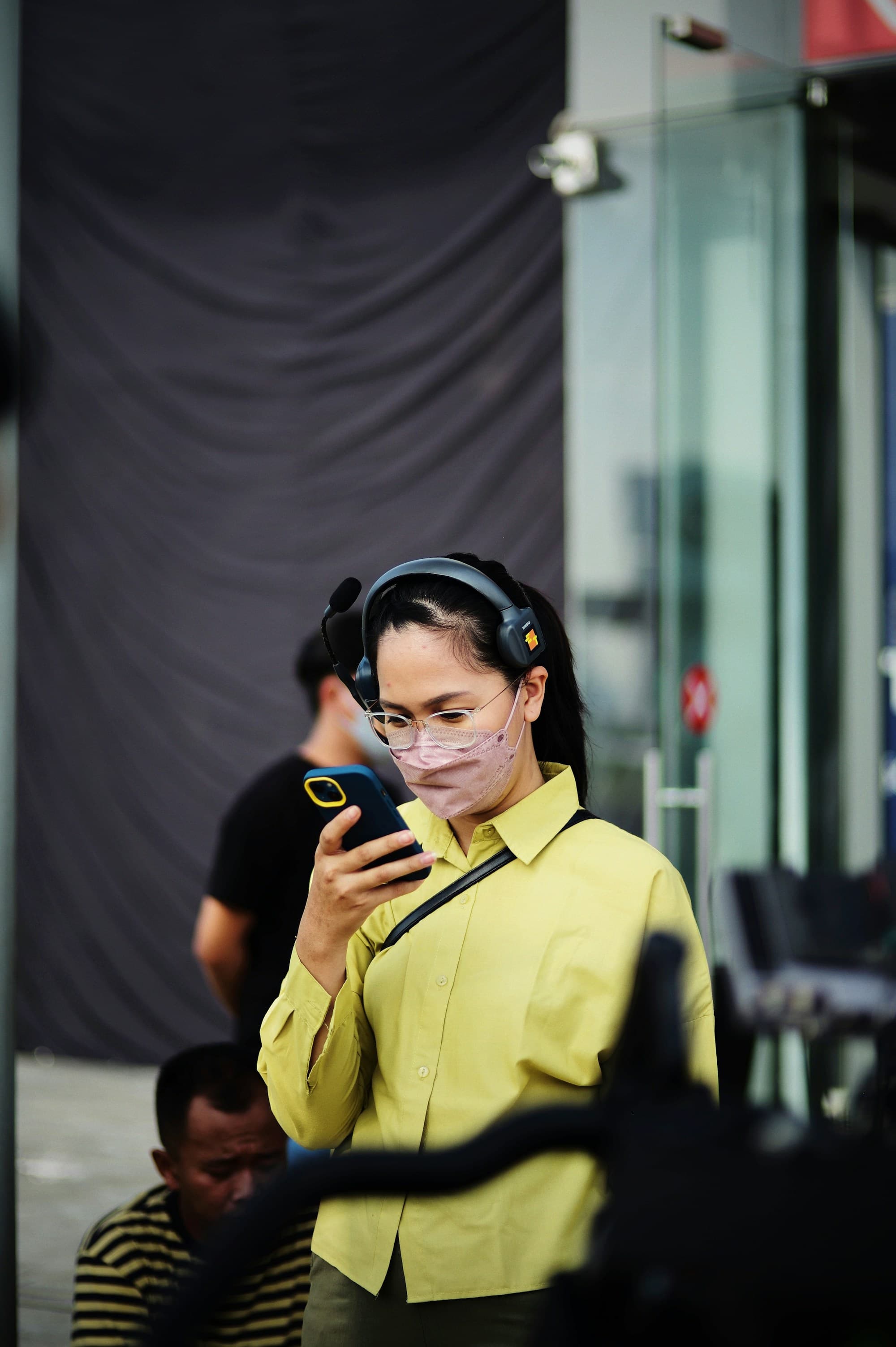 Mobile user wearing headphones and using a phone